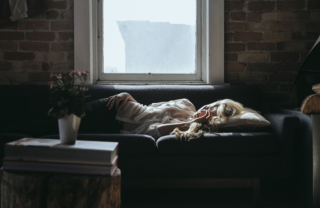 CBD sommeil : flacon d'huile de CBD posé à côté d'un oreiller et d'une lampe douce