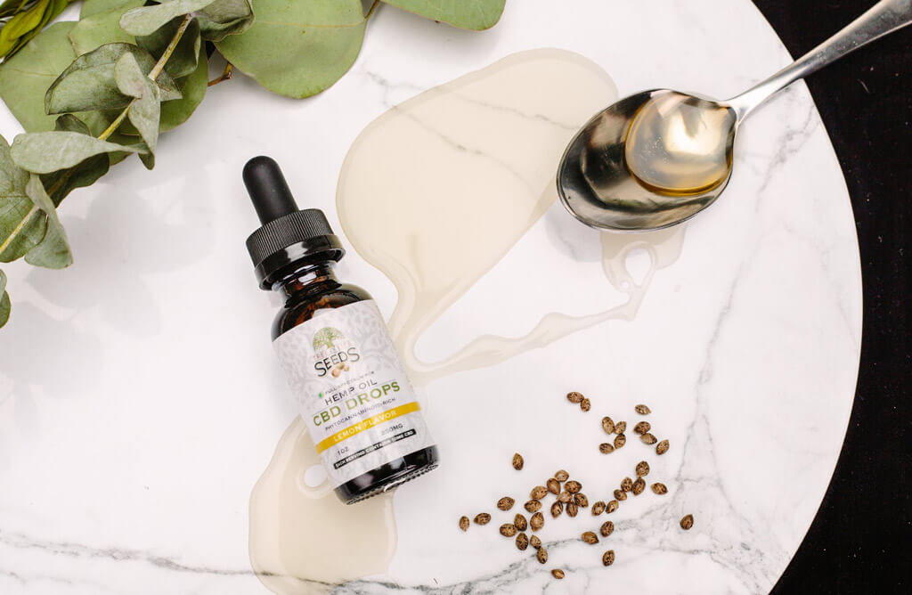 CBD : bouteille d'huile de CBD avec des feuilles de cannabis en arrière-plan