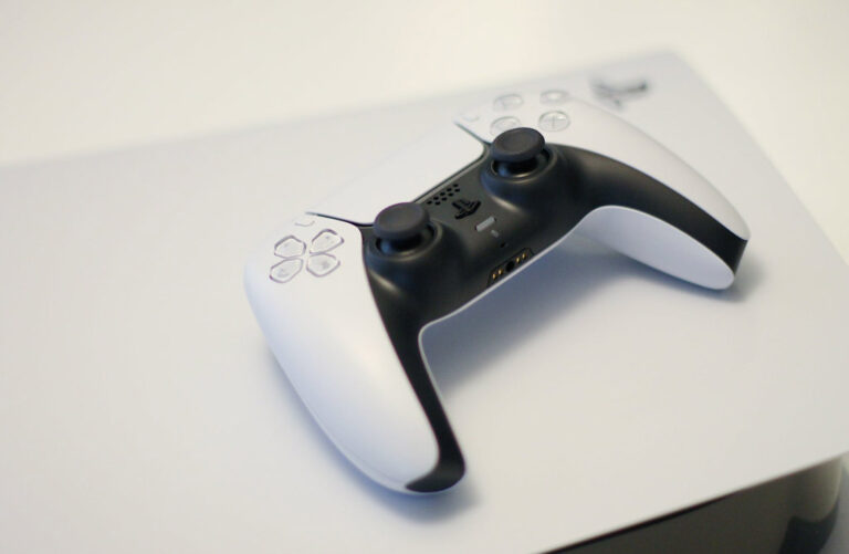 manette PS5 sur PS4 : manette de Playstation 5 à côté d'une console PS4