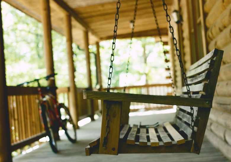 nettoyer mobilier de jardin en bois : personne nettoyant un meuble de jardin en bois avec une éponge et un seau