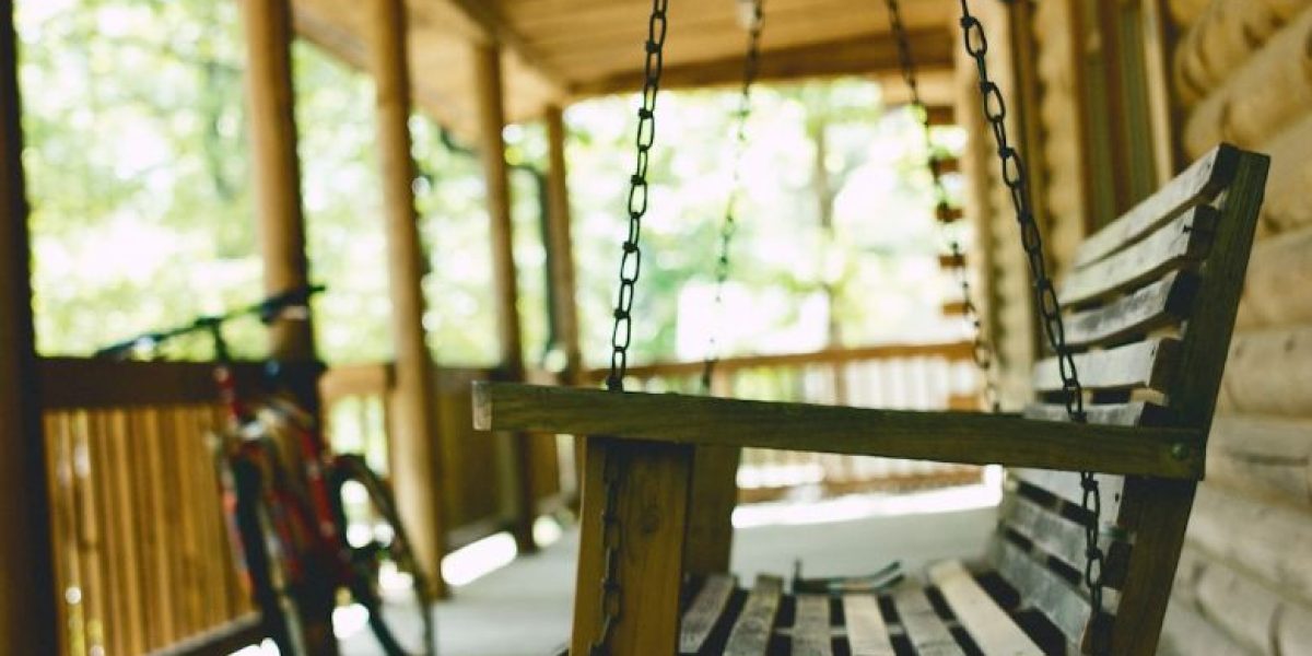 nettoyer mobilier de jardin en bois : personne nettoyant un meuble de jardin en bois avec une éponge et un seau